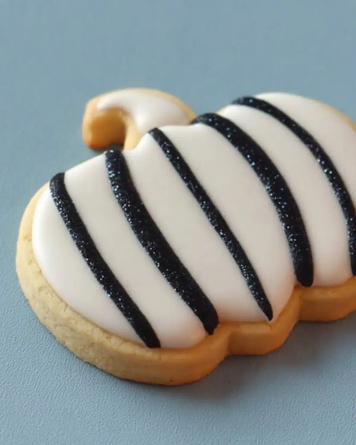 Elegant Black and White Striped Pumpkin Cookie Pumpkin sugar cookie with white icing and black glitter stripes