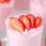 Light and fluffy strawberry mousse topped with fresh sliced strawberries in a clear glass