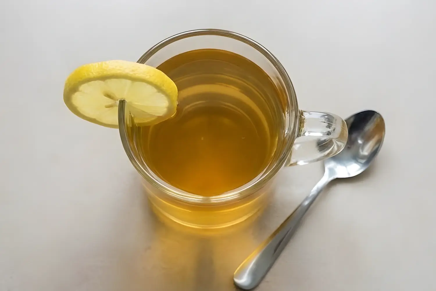 Viral gelatin weight loss drink with lemon slice in a clear glass mug, viewed from above